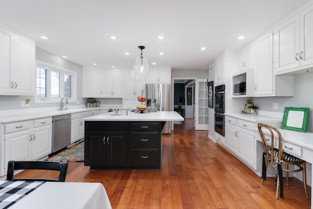 kitchen featuring white cabinetry, appliances with stainless steel finishes, light countertops, and dark cabinetry