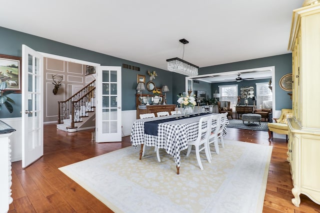 dining space with french doors, stairway, hardwood / wood-style floors, and a ceiling fan