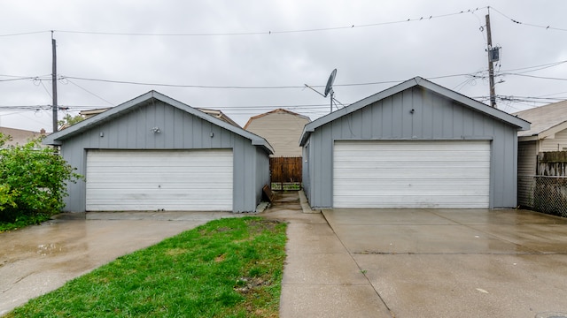 view of front of house featuring an outbuilding, a detached garage, and fence