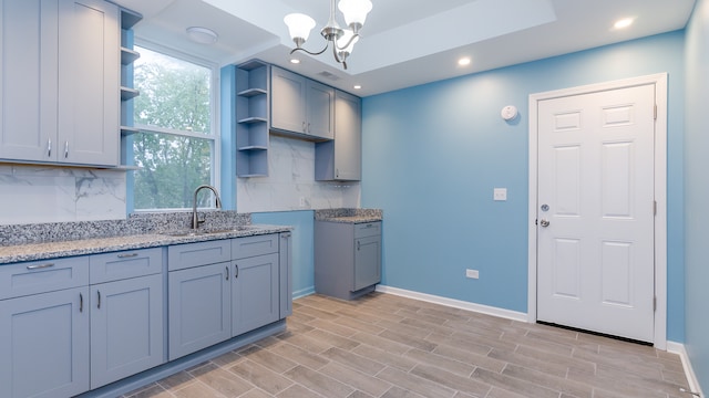 kitchen with tasteful backsplash, a sink, baseboards, and open shelves