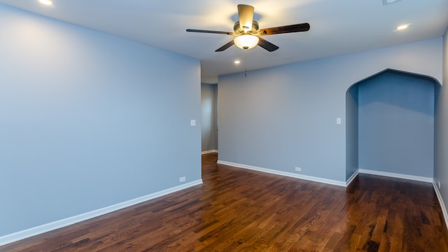 spare room featuring dark wood-style floors, arched walkways, recessed lighting, a ceiling fan, and baseboards