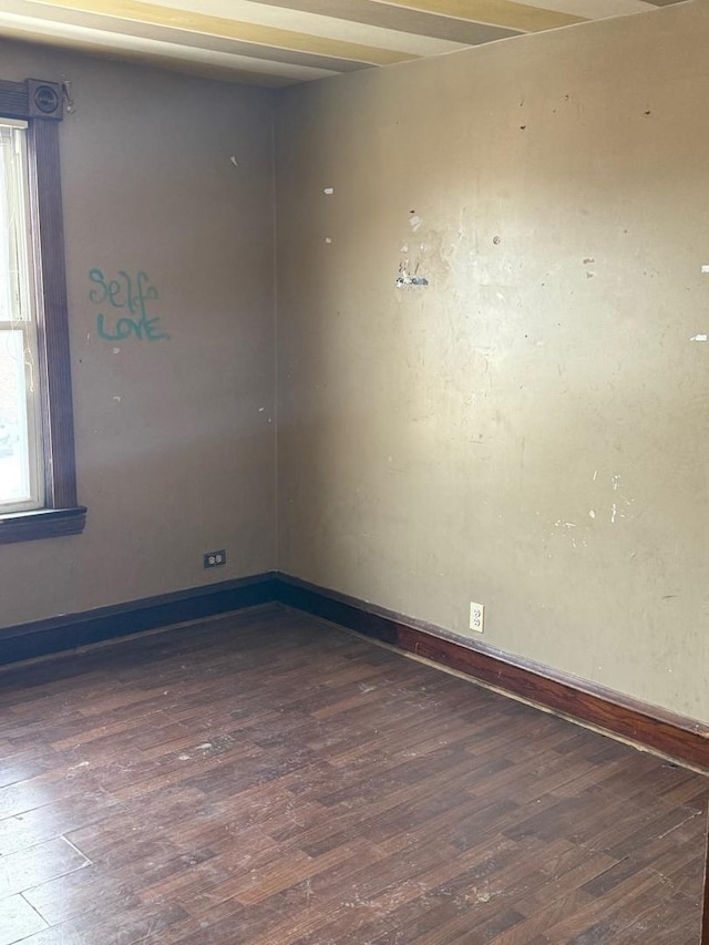 unfurnished room featuring dark wood-type flooring and baseboards