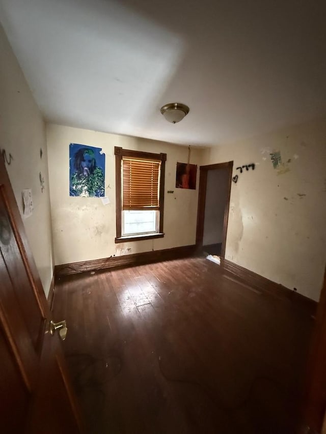 empty room with baseboards and wood finished floors