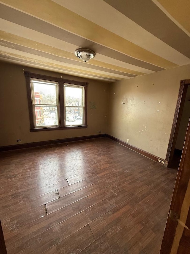 empty room featuring dark wood-style flooring and baseboards