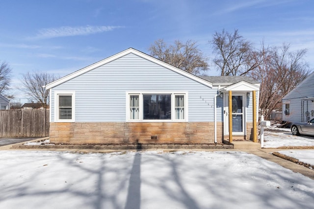 ranch-style home with stone siding and fence