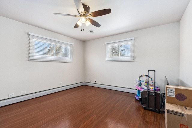 empty room with visible vents, dark wood finished floors, and ceiling fan