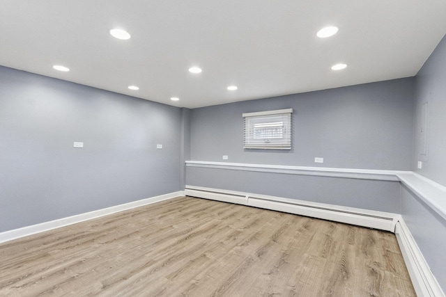 spare room with light wood-type flooring, baseboards, baseboard heating, and recessed lighting