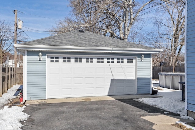 detached garage featuring fence