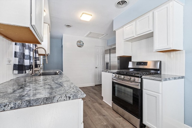 kitchen featuring visible vents, appliances with stainless steel finishes, a sink, and white cabinetry