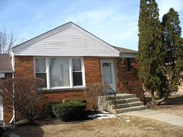 view of front of home with brick siding and roof with shingles