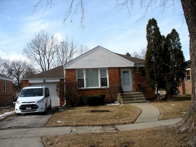 view of front of property with brick siding, an attached garage, and aphalt driveway