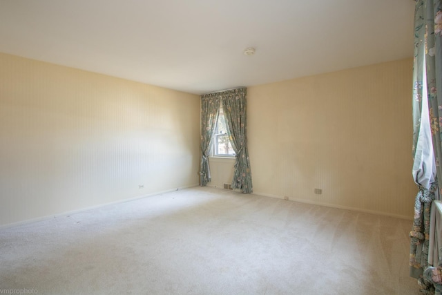 carpeted empty room featuring baseboards