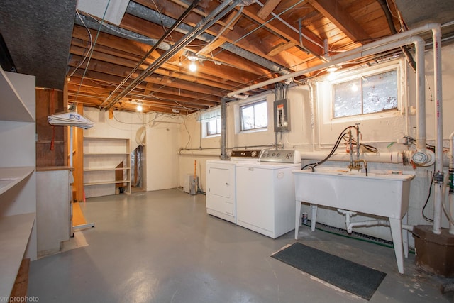 basement with electric panel, independent washer and dryer, and a sink