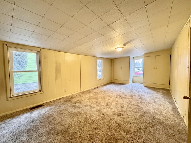 carpeted empty room with visible vents and baseboards