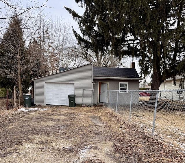 garage featuring driveway and fence