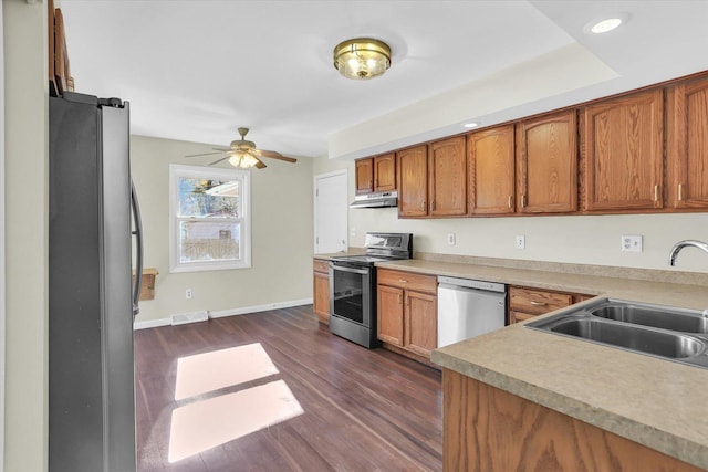 1001 E Sunnycrest Dr, Urbana, IL 61801 - kitchen featuring appliances with stainless steel finishes, a sink, a ceiling fan, dark wood-style floors, and brown cabinets