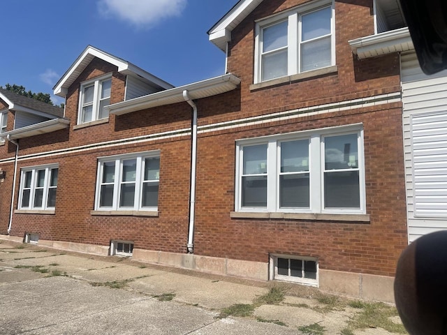 view of side of home featuring heating fuel and brick siding