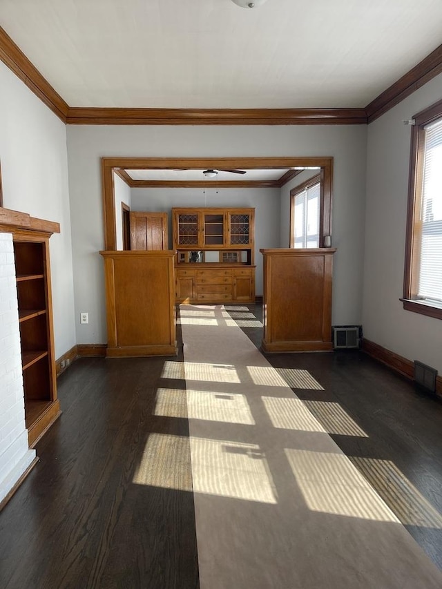 unfurnished living room with plenty of natural light, visible vents, ornamental molding, and baseboards