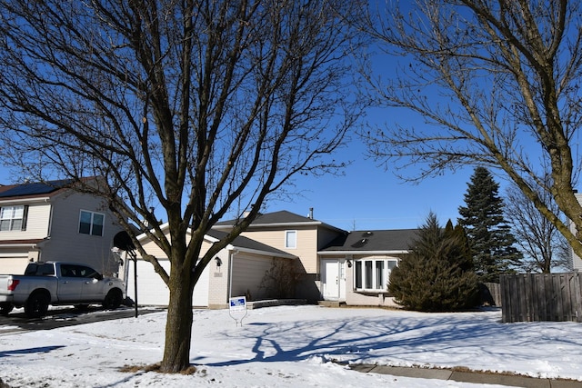 view of front facade featuring a garage, brick siding, and fence