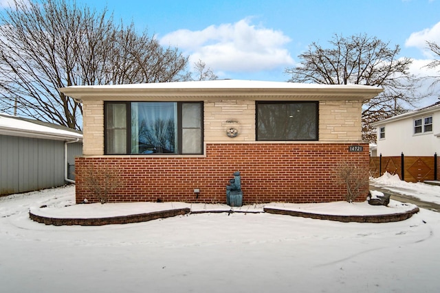 bungalow-style house with brick siding