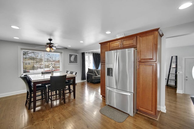 kitchen featuring dark wood-style floors, brown cabinetry, stainless steel fridge, and recessed lighting