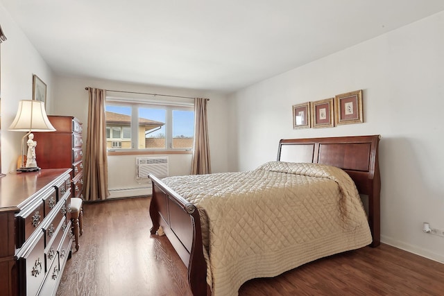 bedroom with baseboards, a baseboard heating unit, dark wood-style flooring, and an AC wall unit