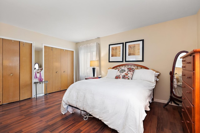 bedroom with multiple closets, baseboards, and wood finished floors