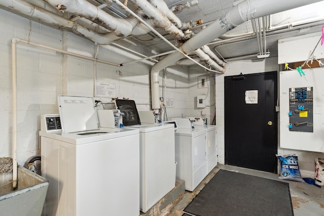 laundry room featuring washer and dryer, a sink, and concrete block wall