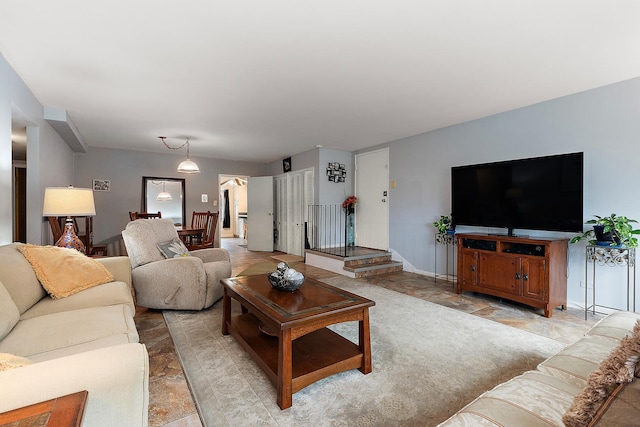 living room featuring stairs and baseboards