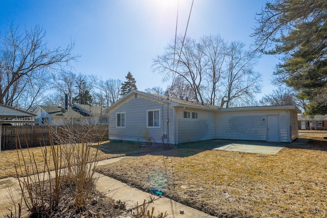 view of side of property with a patio, a lawn, and fence