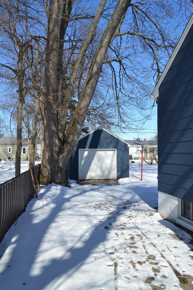 exterior space with a garage, fence, and an outbuilding