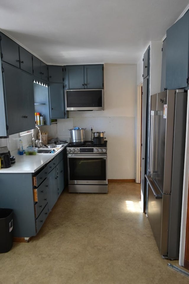 kitchen with a sink, baseboards, light countertops, appliances with stainless steel finishes, and ventilation hood