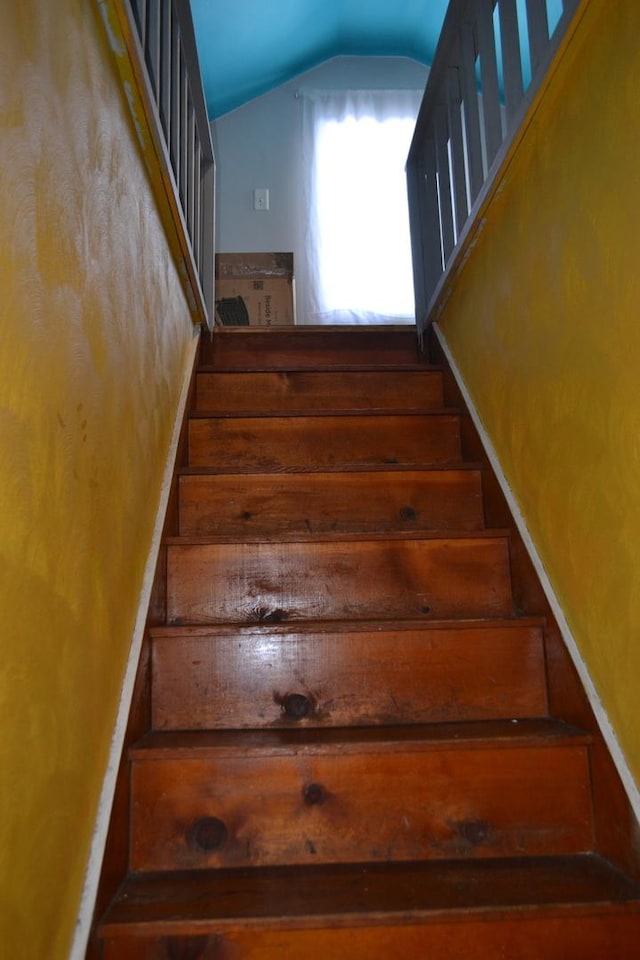 staircase featuring vaulted ceiling