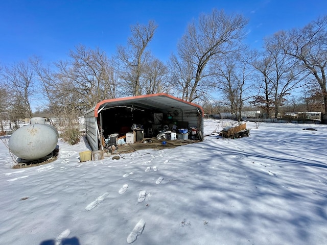 snow covered parking with a carport