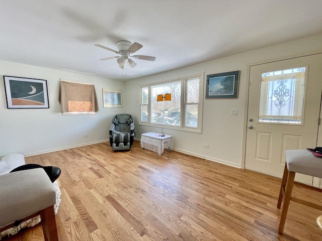 sitting room with baseboards, a ceiling fan, and light wood-style floors