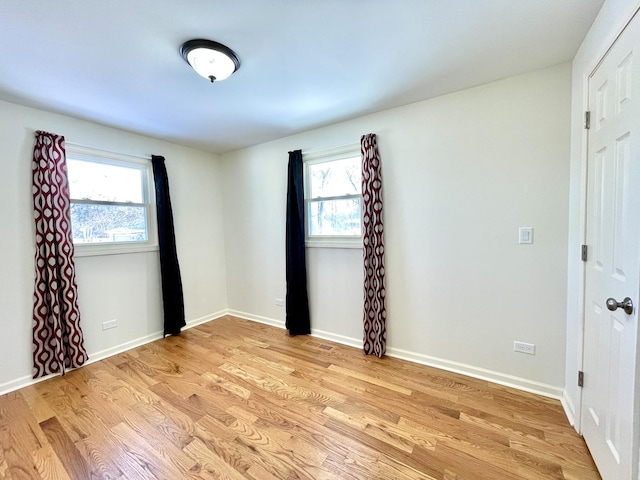 spare room with light wood-type flooring and baseboards