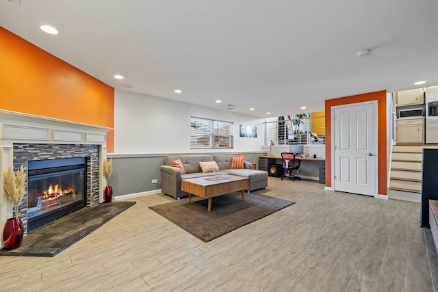 living room featuring a fireplace, recessed lighting, light wood-type flooring, and baseboards