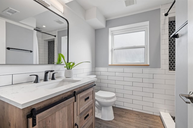 full bathroom with visible vents, toilet, tile walls, and a tile shower