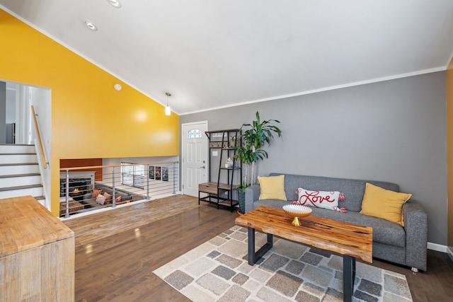 living room with wood finished floors, crown molding, baseboards, stairs, and vaulted ceiling