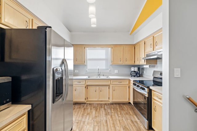 kitchen with under cabinet range hood, appliances with stainless steel finishes, light brown cabinetry, and a sink