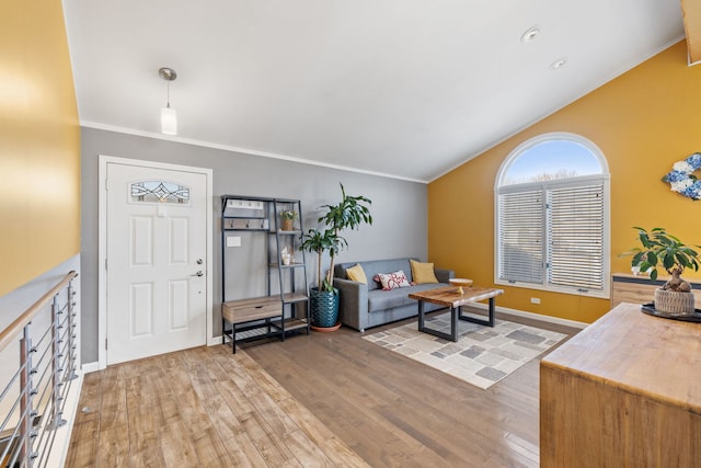 living room featuring ornamental molding, baseboards, lofted ceiling, and wood finished floors