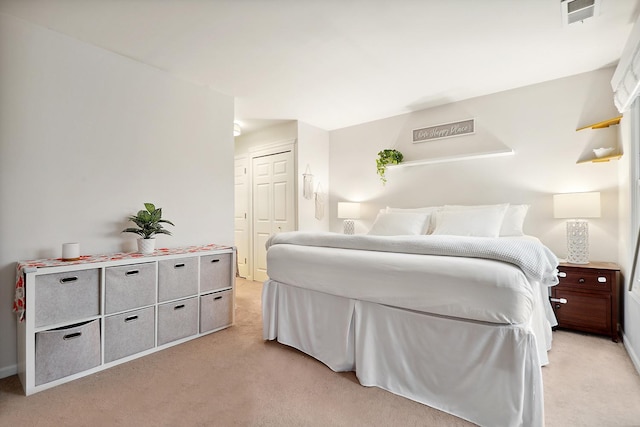 bedroom featuring visible vents, a closet, and light colored carpet