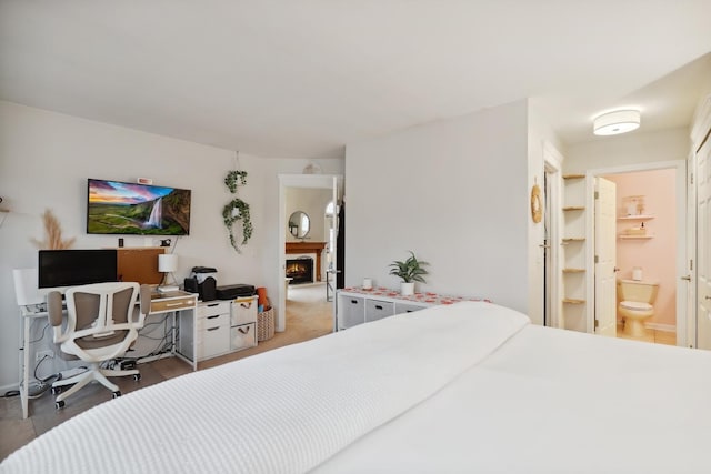 bedroom with a warm lit fireplace and ensuite bath