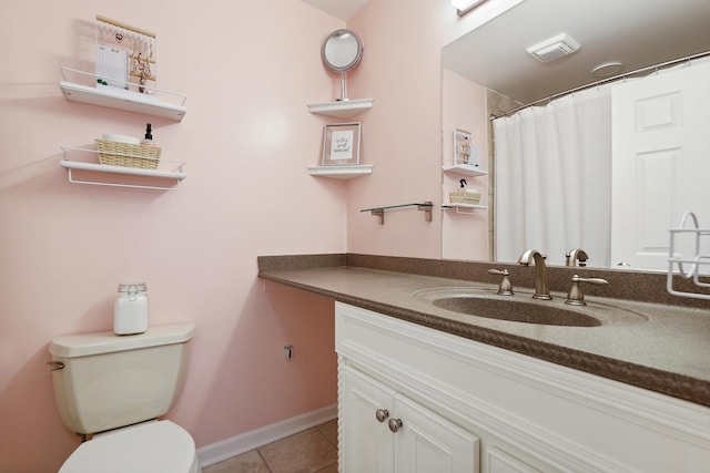 bathroom featuring baseboards, vanity, toilet, and tile patterned floors