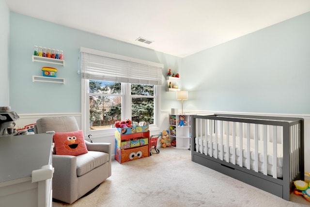 carpeted bedroom with a nursery area and visible vents