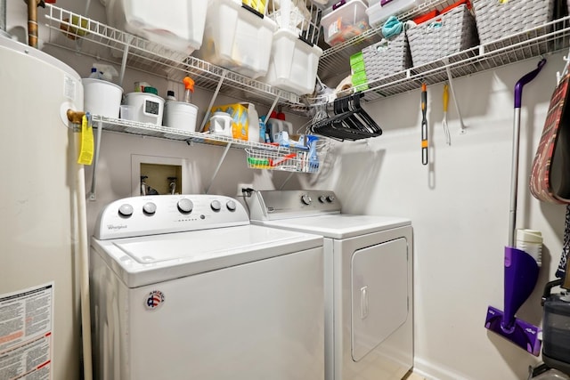 washroom featuring laundry area, washing machine and dryer, and gas water heater