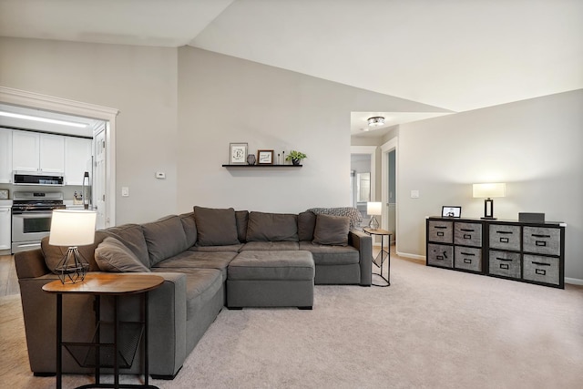 living room featuring vaulted ceiling, baseboards, and light colored carpet