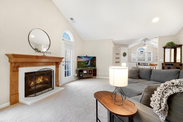 living area with lofted ceiling, a tile fireplace, carpet flooring, visible vents, and baseboards