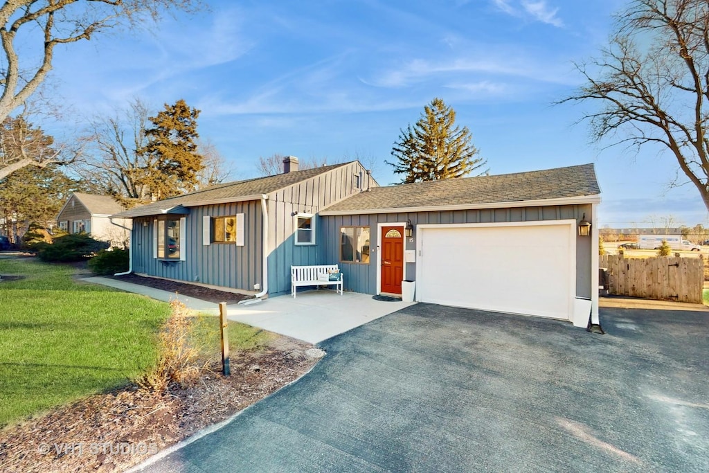 15 Pamela Rd, Lake Zurich, IL 60047 - ranch-style home featuring driveway, a chimney, board and batten siding, a front lawn, and a garage