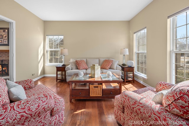 living area featuring dark wood finished floors, a healthy amount of sunlight, and a fireplace